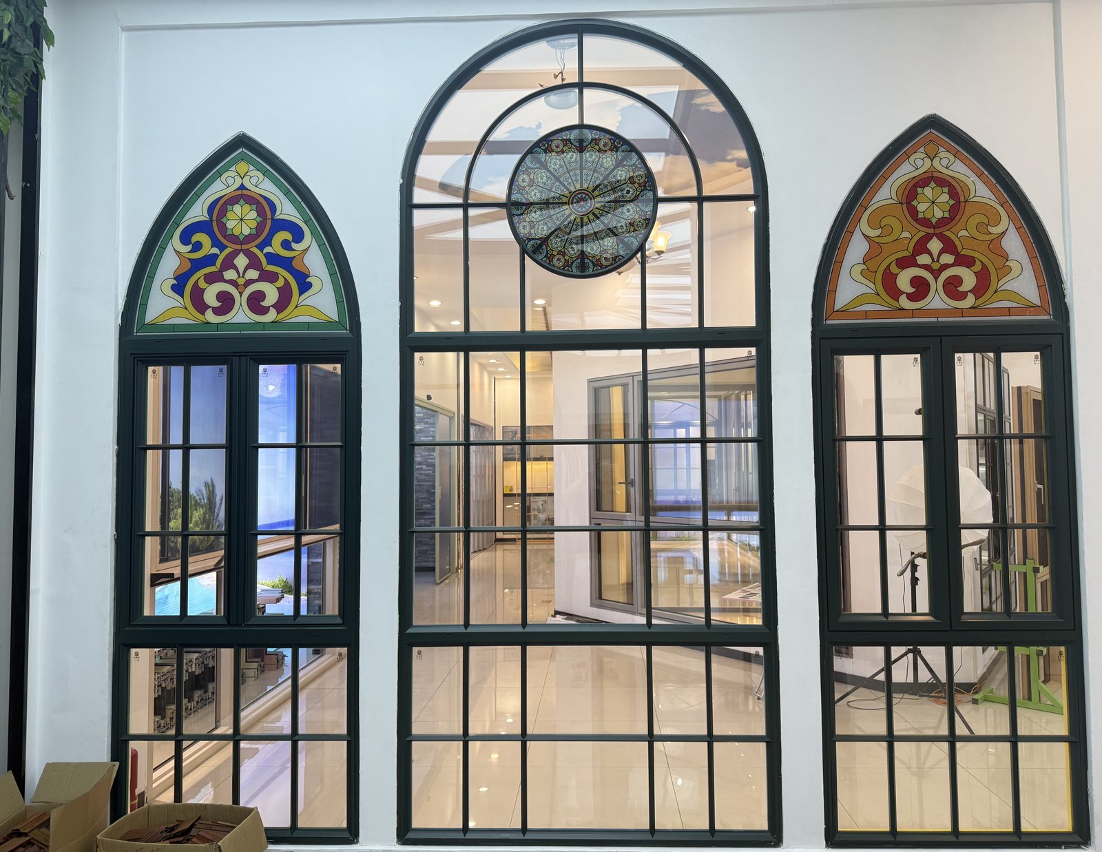 Dark green arched windows with stained glass panels and a circular feature light