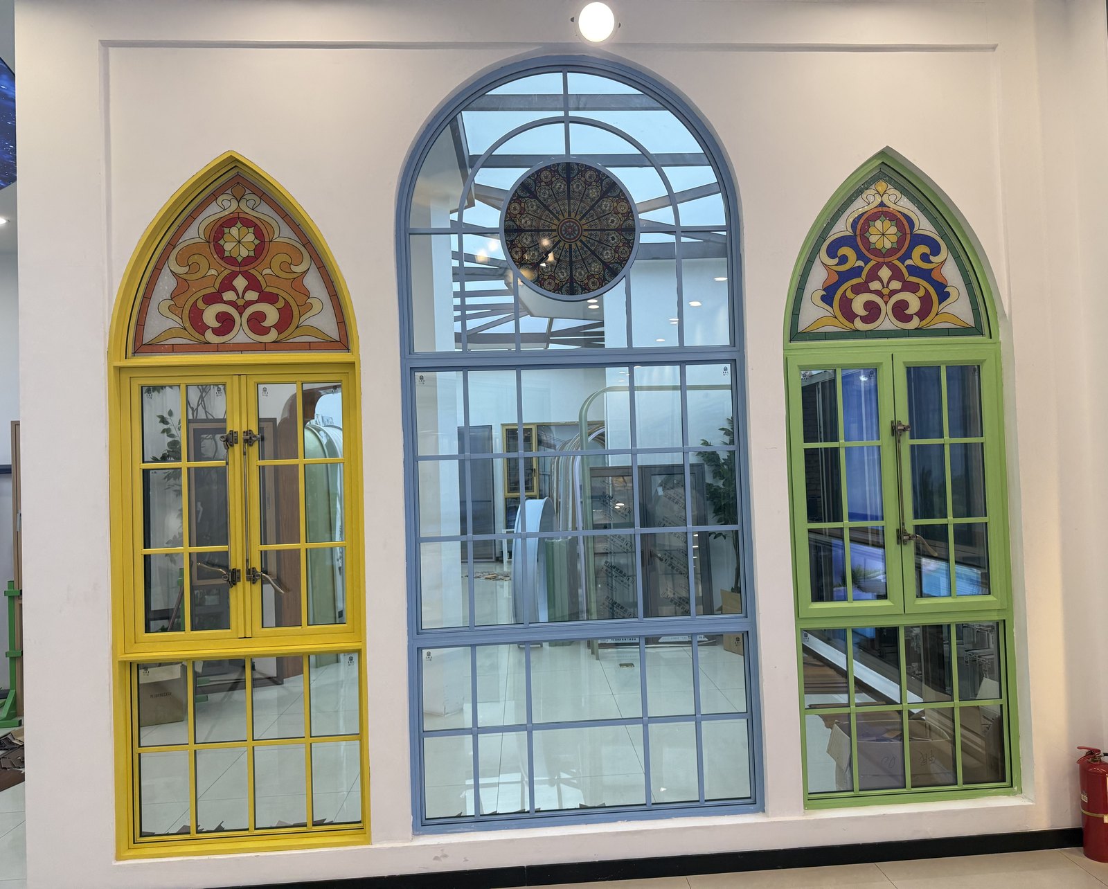 Three arched aluminum windows with decorative stained glass in yellow, blue and green frames