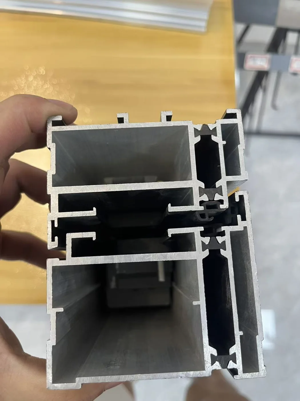 Real thermal-break aluminum profile section showing the polyamide bridge and gasket chambers
