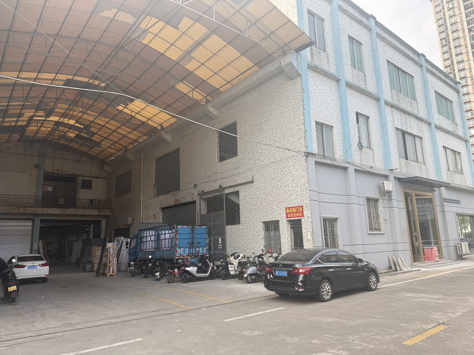 Factory exterior or entrance with the company sign visible